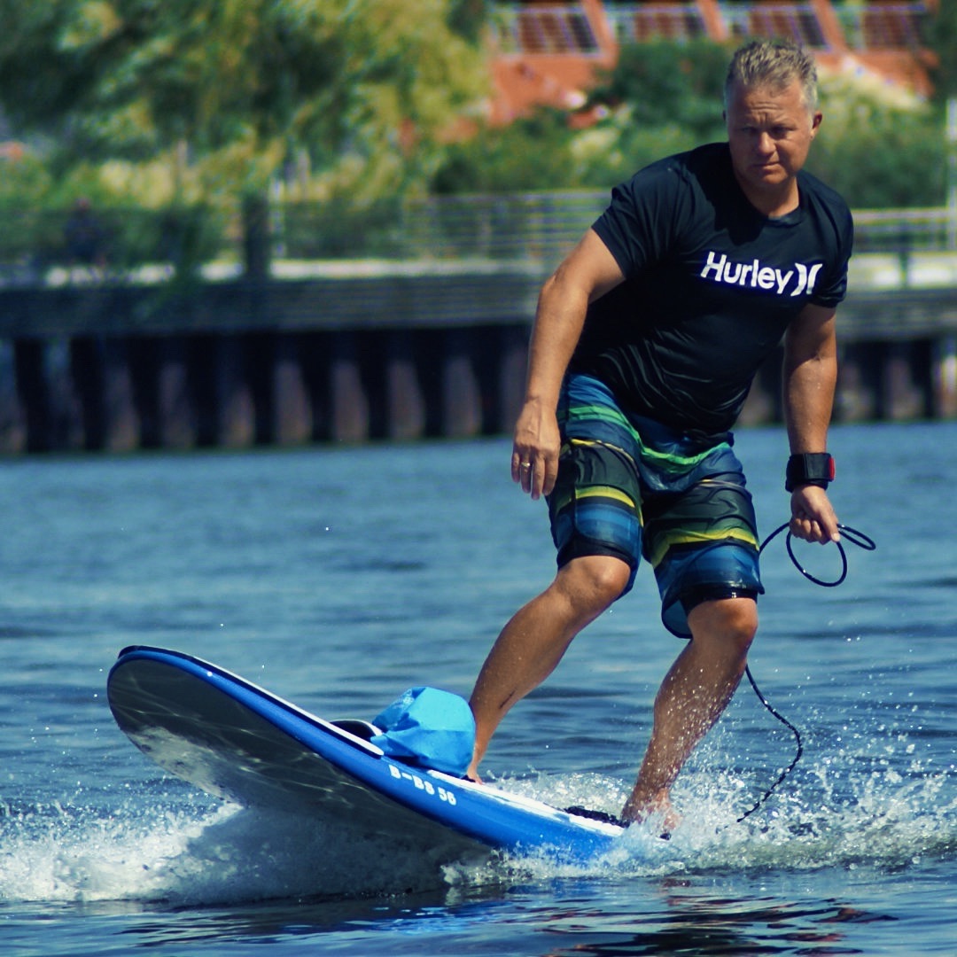 Andreas Lakeberg riding an electric surfboard
